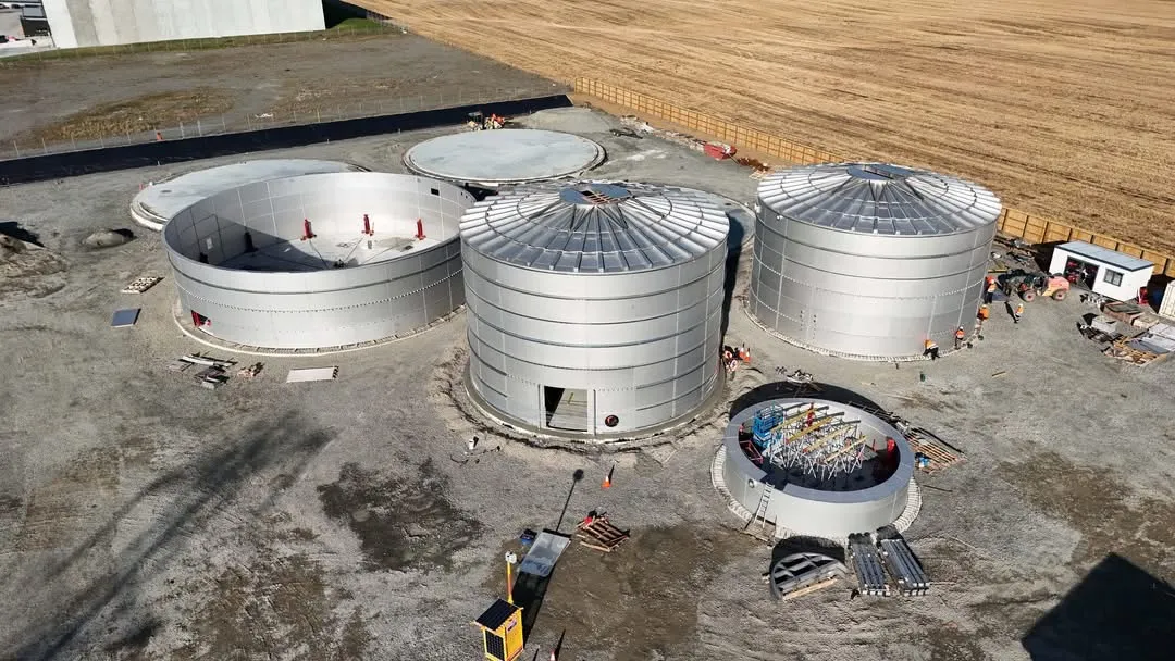 Aerial view of a construction site with several bolted steel tanks under way