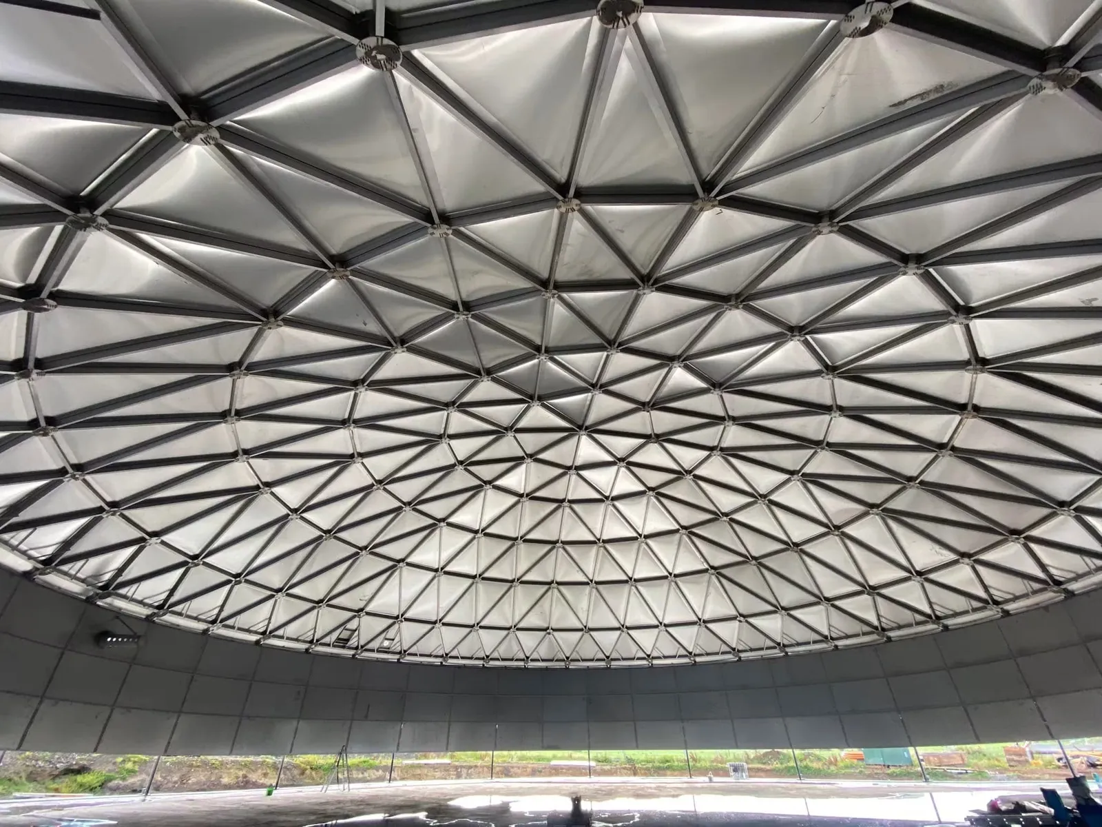 Aluminium geodesic dome roof seen from inside a completed bolted steel tank