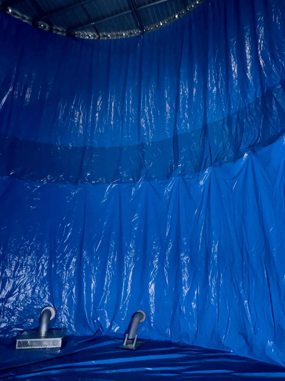 Interior of a tank with a new blue liner fitted and pipework connected
