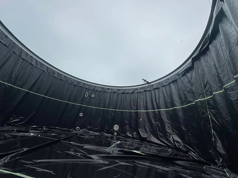 The same wall covered in new black liner, floor lined to the wall, the rim open to the same sky